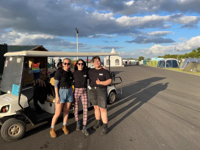 Our students Laura and Fraser stood each side of our graduate Carla at download festival 2022