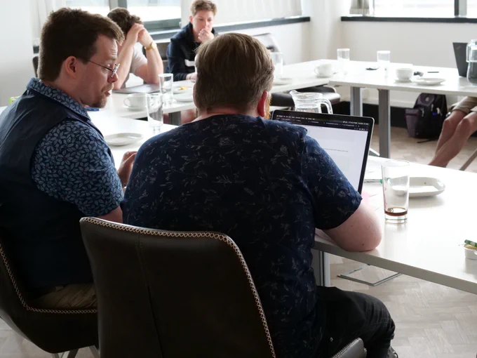 Two people coding at a laptop