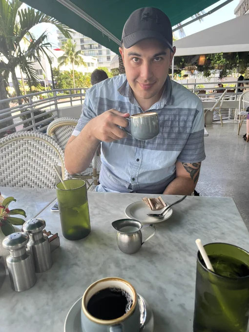 Jon drinking coffee at a cafe
