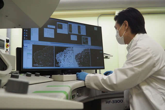 Image shows Paul Chen examining nanoparticles using a scanning transmission electron microscope. (Photo: Tyler Irving)