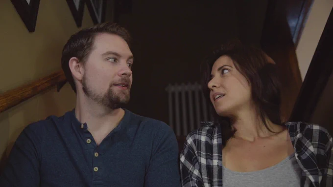 Fred and Ana sit on a staircase, gazing at each other