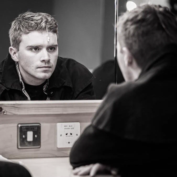 Ben, dressed as JD, looks into a mirror