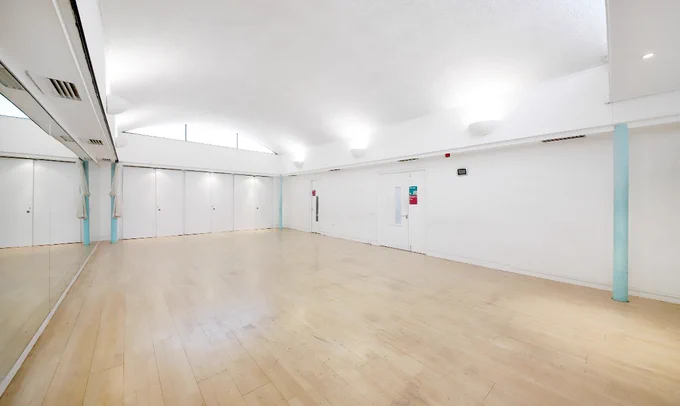 a photo of a Clean break studio. It is a spacious, bright studio with a wooden floor and white walls.
