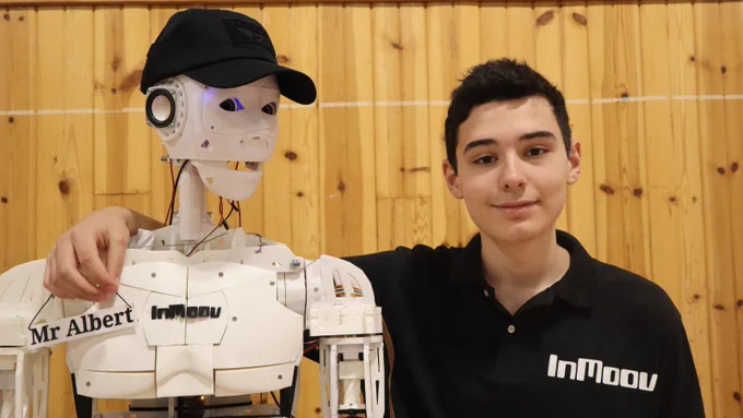Jacob Ledoux from Oromocto High School smiling next to the #InMoov Robot that he built.