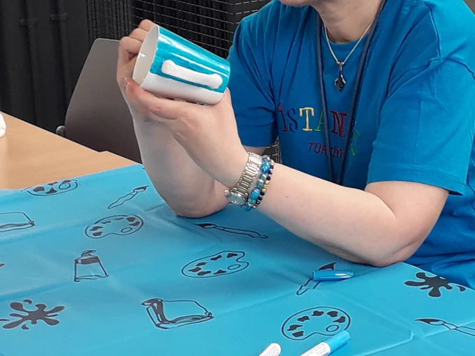 Person painting on a cup
