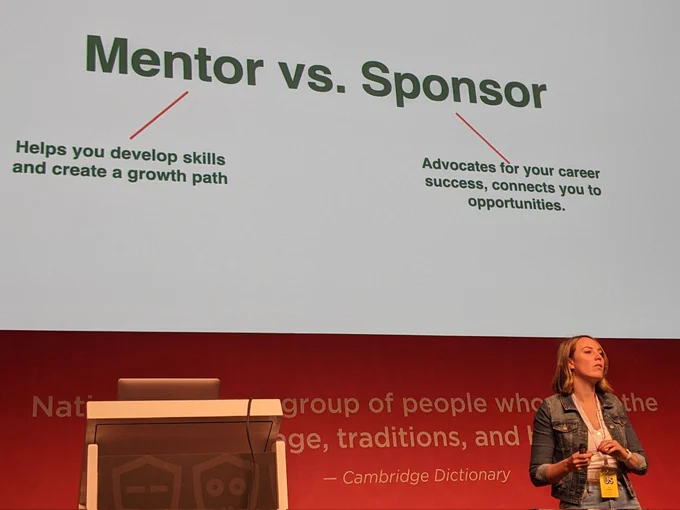 Iris speaking in front of a slide titled "Mentor vs. Sponsor", where Mentor is described as "Helps you develop skills and create a growth plan", Sponsor as "Advocates for your career success, connects you to opportunities"
