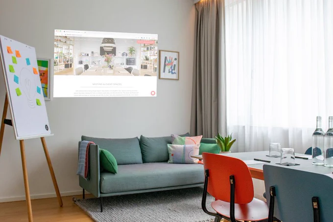 Zoku Vienna MeetingLoft with couch, flipchart and wall projector.