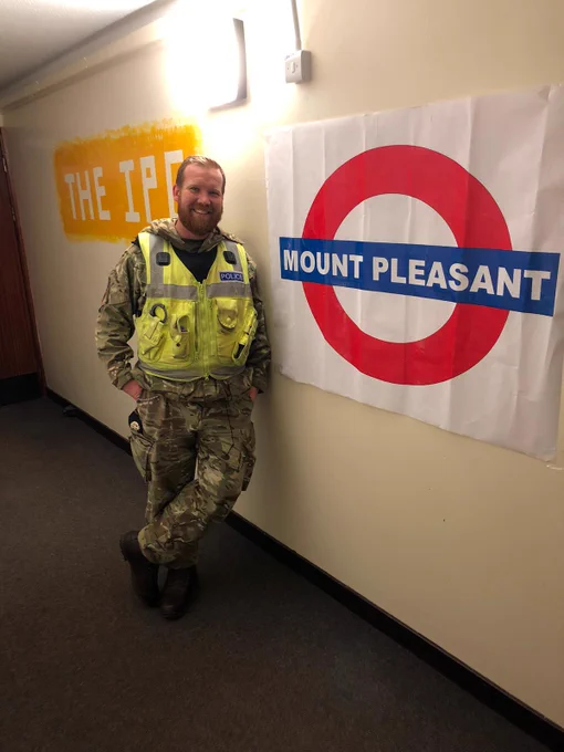 Image shows an RAF policeman in front of a Mount Pleasant sign in the design of a London underground sign.