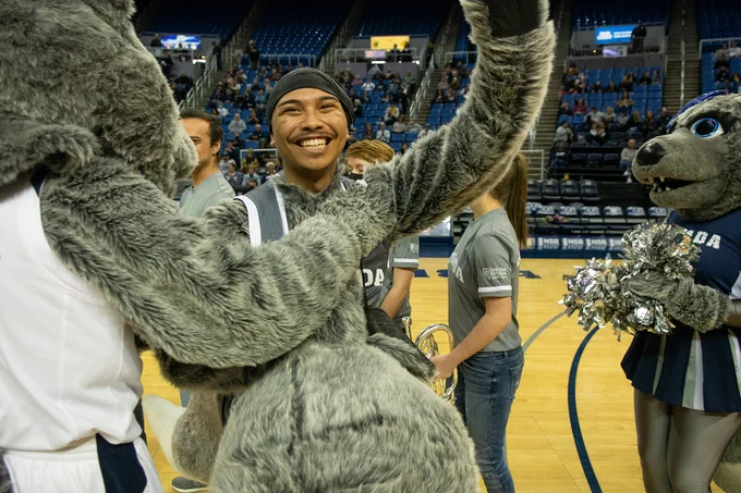 Nevada Wolf Pack Mascot, Alphie, revealed as University of Nevada, Reno student Nolan Caberto, with other mascots around him, in Lawlor Events Center.