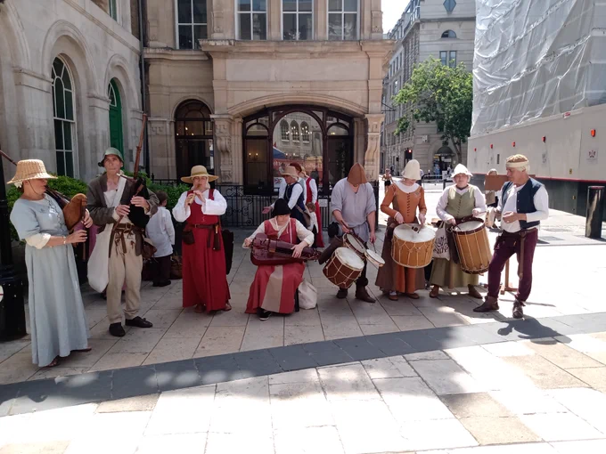 Group of people dressed in Tudor outfits and playing music.