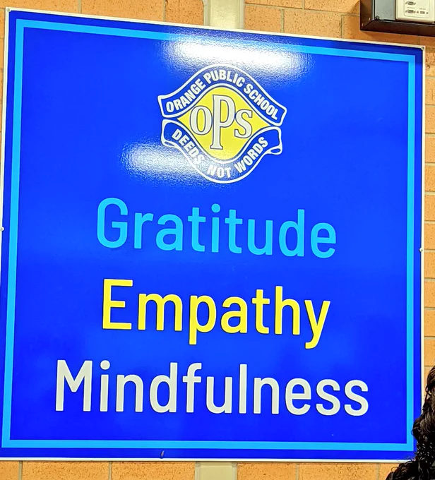 A sign with Orange Public School motto - deeds not words, gratitude, empathy, mindfulness