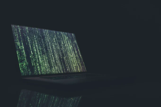 Laptop displaying binary code on the screen.