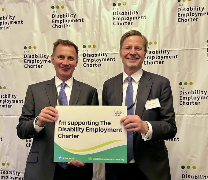This is an image of Jeremy Hunt MP and David Forbes Nixon standing in front of a white backdrop with the disability employment charter logo, standing together and jointly holding a sign stating “I’m supporting the Disability Employment Charter”