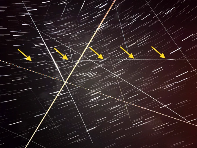 Long exposure with highlighted classified satellite path (yellow arrows, right to left).