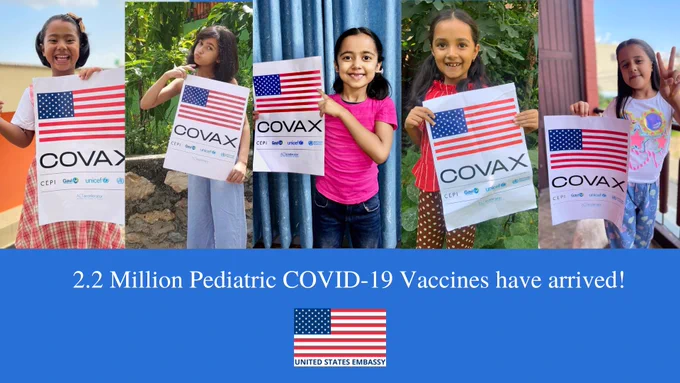 A collage of five Nepalese girls, each smiling and holding a sign with an American flag and the word COVAX.  Text at the bottom of the image reads: 2.2 million pediatric COVID-19 vaccines have arrived!