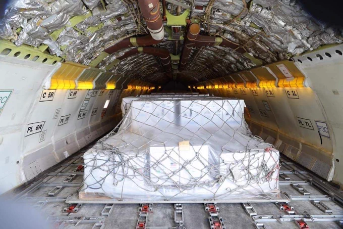 A pallet of boxes containing vaccines in the body of a cargo aircraft.