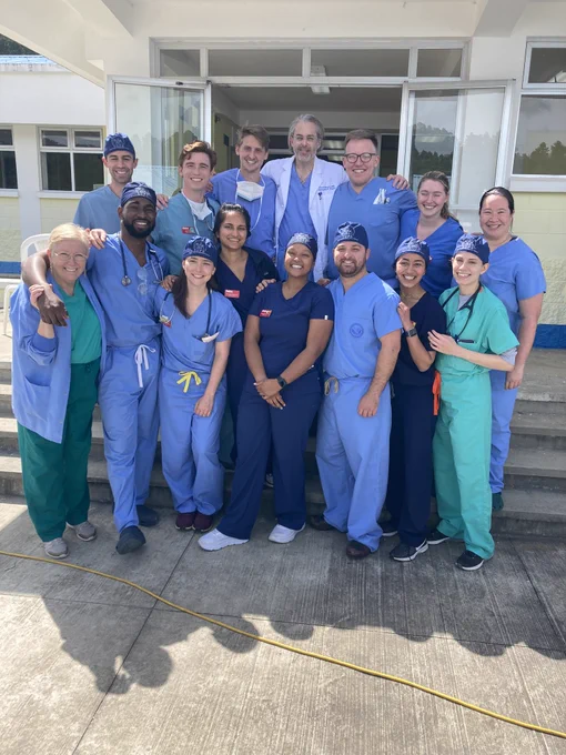 Group of students, residents, and faculty gather together for a group photo. 