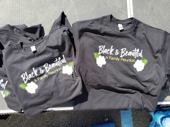Two black tshirts with white flowers and "Black & Beautiful A Family Reunion" written on them