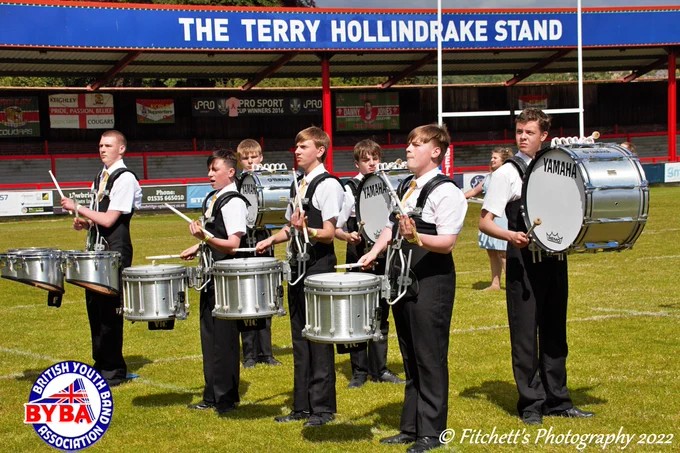 3 snare drummers, 3 bass drummers, and 1 tenor drummer from Revolution drumming on a rugby pitch