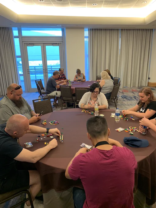Group of adults around conference table building with LEGO bricks.