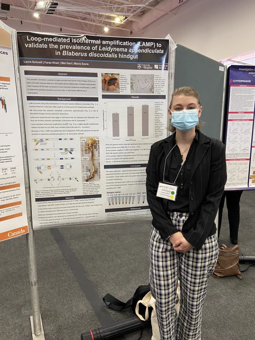 Laura standing beside her poster on parasite prevalece in cockroach hindguts