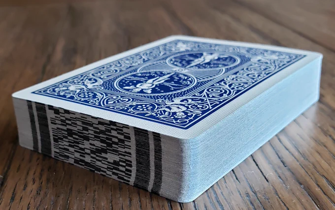 A deck of cards with digital marks printed on the edge of each card.