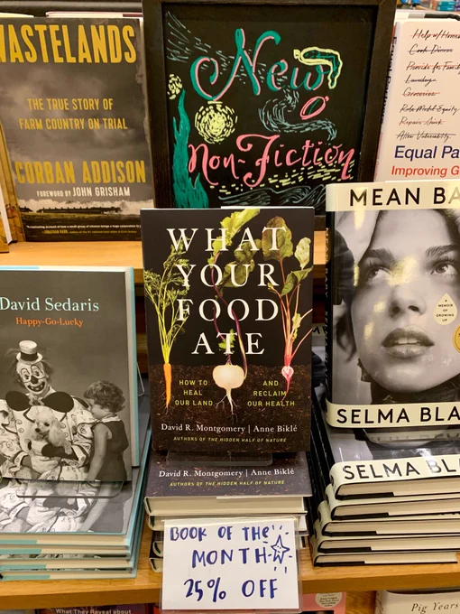 The New Non-Fiction table in University Book Store: a display of non-fiction books, most prominently featured is "What You Food Ate" by David R. Montgomery & Anne Biklé with a "Book of the Month 25% off" sign by it.
           