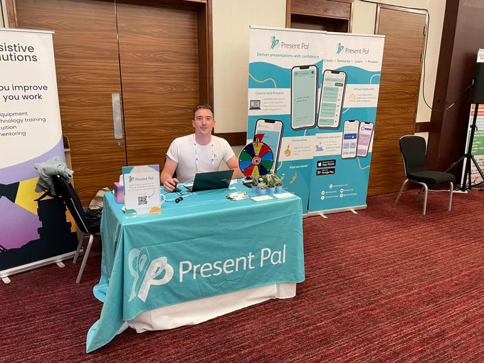 Joe Dawber sitting behind a table with Present Pal branded items.