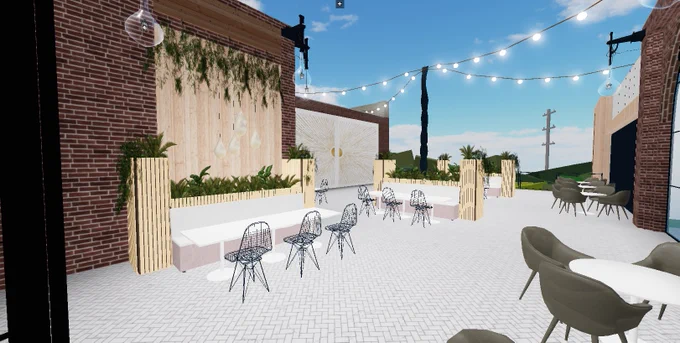 This photo shows a food hall outdoor patio with wired outdoor lights being lit on daytime