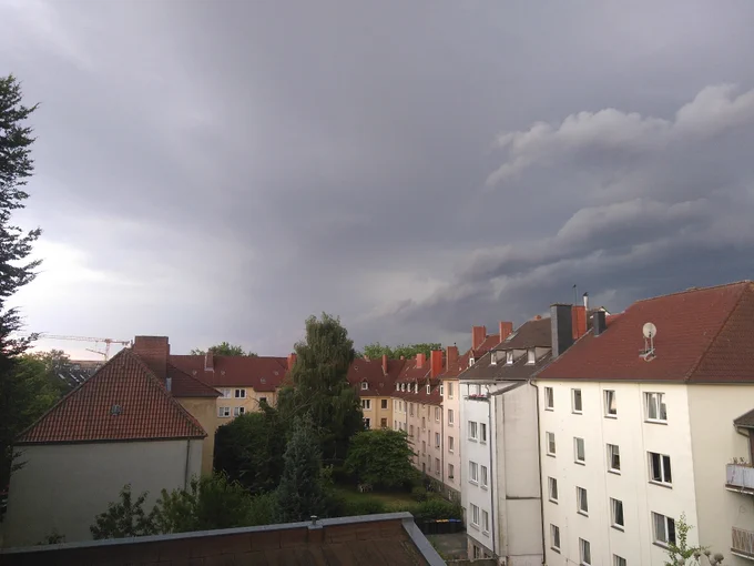 Dunkle Gewitterwolken auf der einen Himmelhälfte. Blauer Himmel auf der anderen Hälfte.