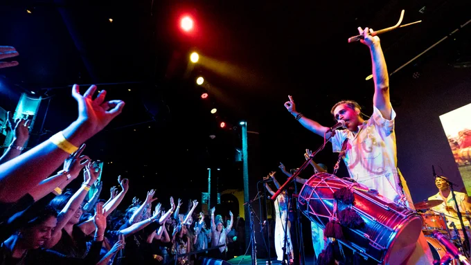  Red Baraat lead singer Sunny Jain wearing his dhol throwing his hands up for the crowd, the crowd insync with his motions. Photo by John Shore.