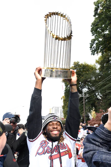 Touki Toussaint smiles as he holds up the World Series trophy.