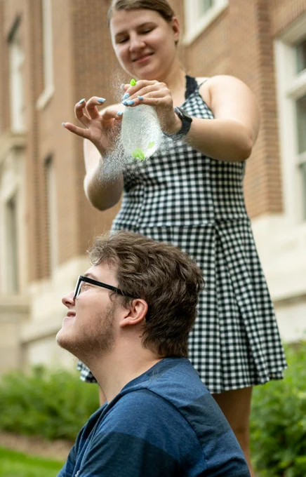 Washburn University student Shalynn Long pops a balloon above the head of Eastern Illinois University student Rob Le Cates at the Associated Collegiate Press Mega Workshop in Minneapolis July 16, 2022.