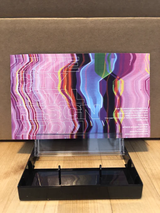 A look at the complete paper liner for the new Mute City album - a blurred and sheared VCR-esque color blur with the title "Total Resignation" across the front and the track list on the other side.
