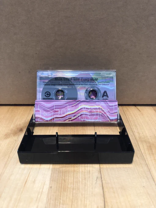 A new Mute City cassette opened up so you can see the inside - a nice clear cassette with black tape and a black case.