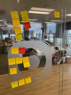Photo of post-it notes with topics for discussion stuck to a glass wall