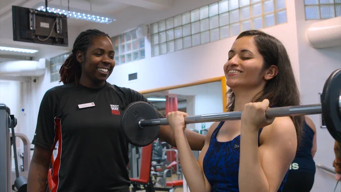 Visually impaired women lifting a barbell in the gym 
