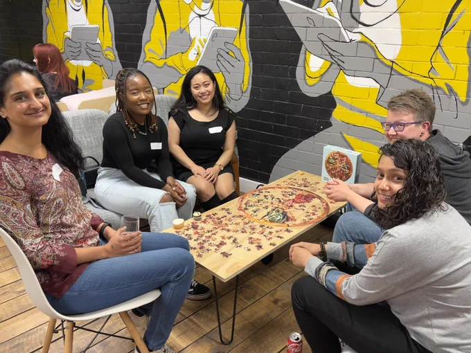 another group of attendees assembling a round pizza jigsaw