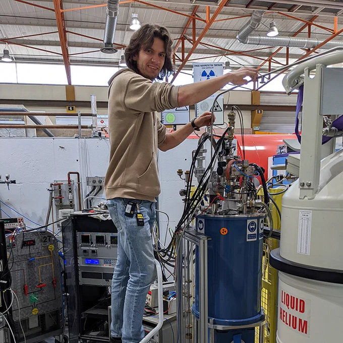 Xaver Brems inserts his probe into the cryostat, to reach the superconducting phase. The technical challenge was to maintain stable temperatures despite the large current that he had to apply. © FRM II / TUM
