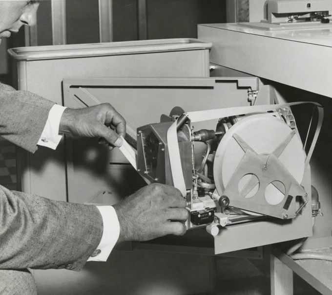 CBI Image of the Day. In 1961 a view inside of the Control Data 350 Paper Tape Reader, BRPE II Tape Punch and a man adjusting the paper tape using both hands. He is dressed in a suit and there is a role of paper tape that is perhaps 10 inches in diameter. Peripherals were important to CDC from the start of the firm in 1957 and would soon grow into about 30 percent of the company's revenue stream (by 70s).