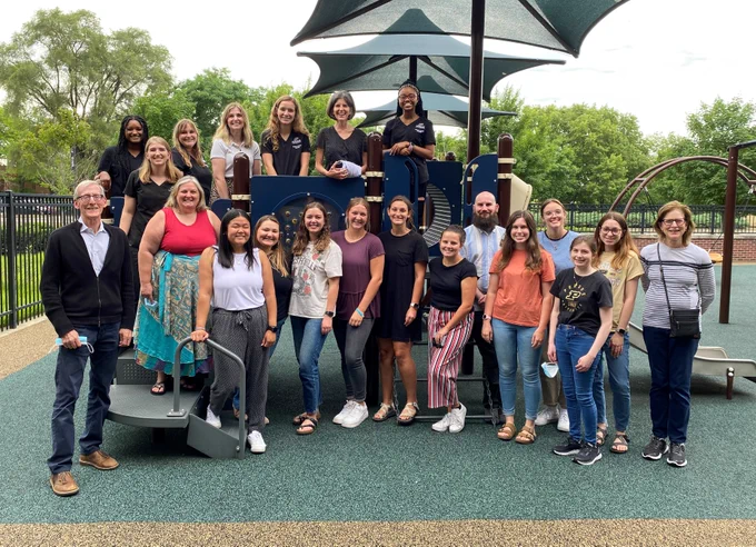 photo of Summer Fun faculty, clinicians, staff, and students grouped around playground equipment