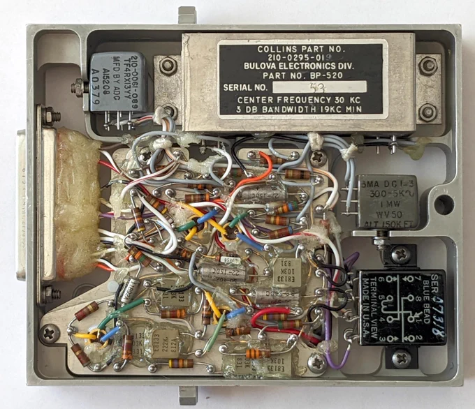 The circuit board has a bunch of transistors, resistors,capacitors, and other components mounted haphazardly on a board.