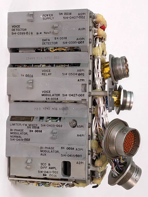 The premodulation processor is a block of gray metal modules with four round military-style connectors on the side.
