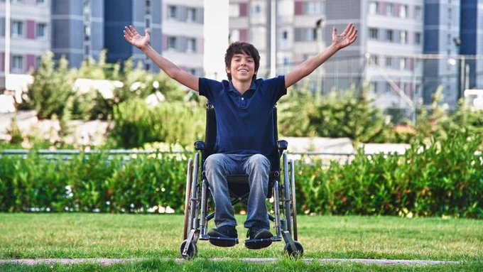 young man in wheelchair with arms outstretched