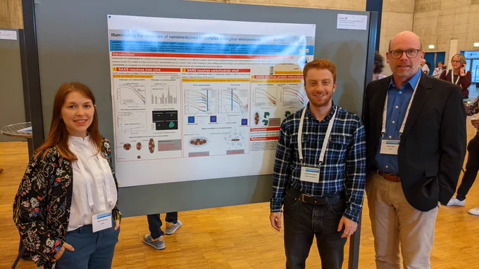 PostDoc Dr. Daina Romeo, PhD Leonard Krupnik and Nanointercell lab head Dr. Peter Wick in front of Leo's poster on illuminating the structure of nanomedicines in complex biological environments.