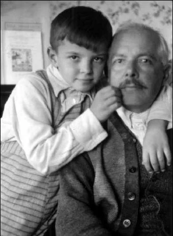 Béla Bartók is on the right of the picture. His young child has his arm around his neck. They're both looking at the camera.