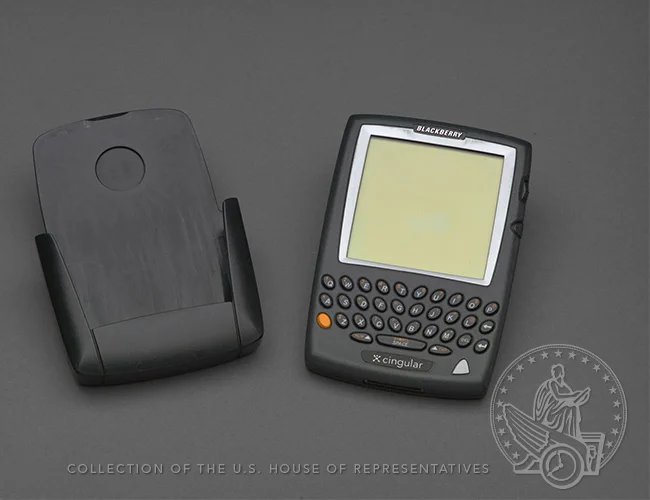 A BlackBerry 957 Wireless Handheld device with holster.