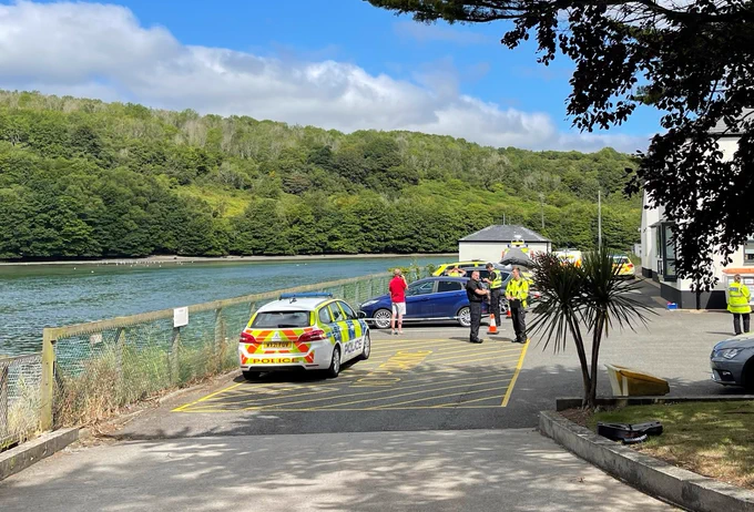 Police cars and police officers outside Looe police station in the sunshine