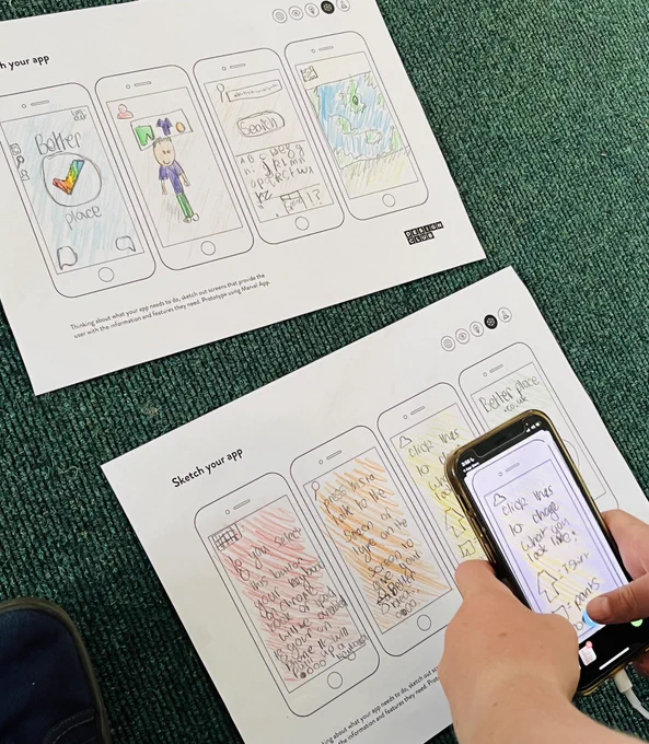 Student taking pictures of their sketches.