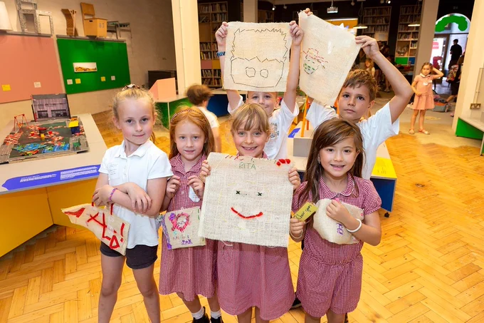 Children show off the craft bags they have made